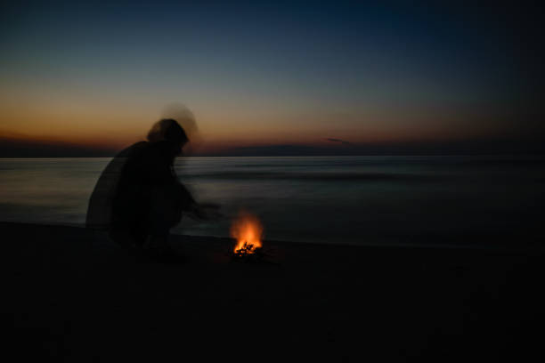 istock dramatic sunrise over the baltic sea with rocky beach and two people warming hands by fire 1001712742