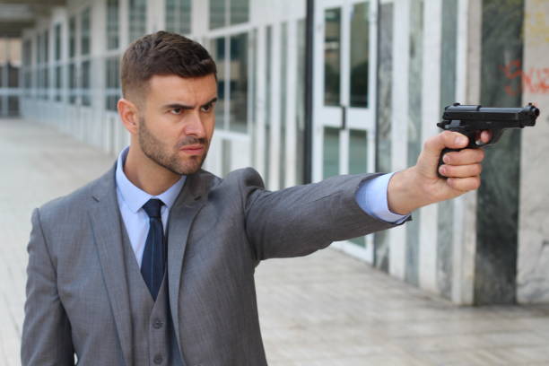 pistolet de portefeuille élégant homme en colère - gun men holding handgun photos et images de collection