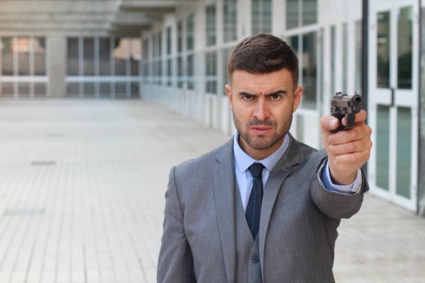 istock Businessman pointing at camera with a gun 1001718854