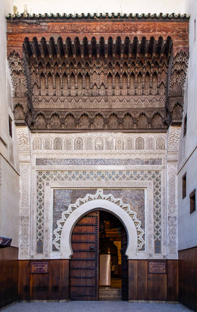 Ornate Moorish arch gate in the medina of Fes Morocco Ornate cedar carved Moorish arch gate decorated alabaster carvings in the medina of Fes, Morocco marrakesh riad stock pictures, royalty-free photos & images