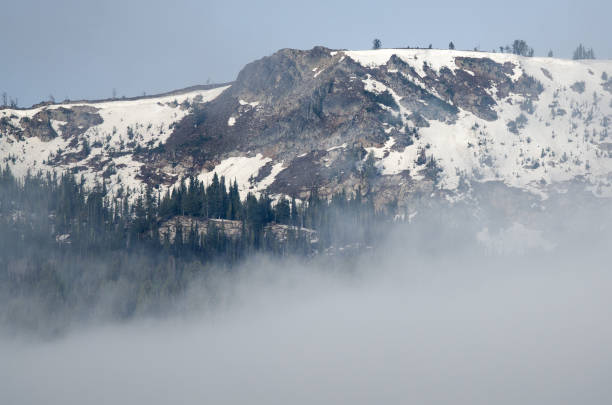 istock Snowy Mountain Peaks Standing Above the Clouds 1001731220