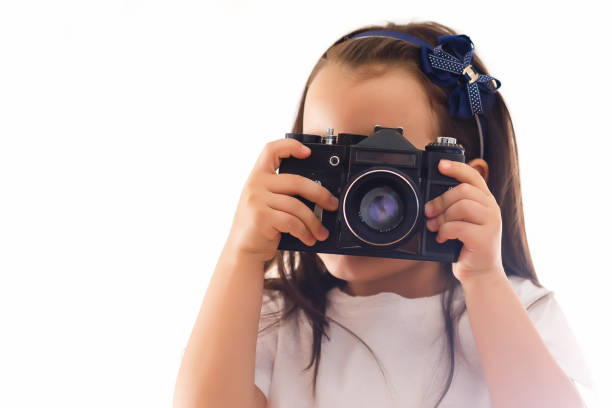 istock Girl taking a picture with a professional retro camera isolated on white 1001732114