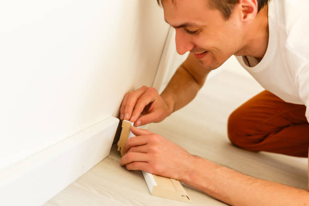istock Man putting new skirting board in house 1001738146