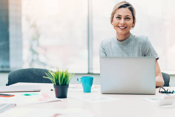 Leading with a smile Beautiful businesswoman sitting in her office, with copy space women satisfaction decisions cheerful stock pictures, royalty-free photos & images