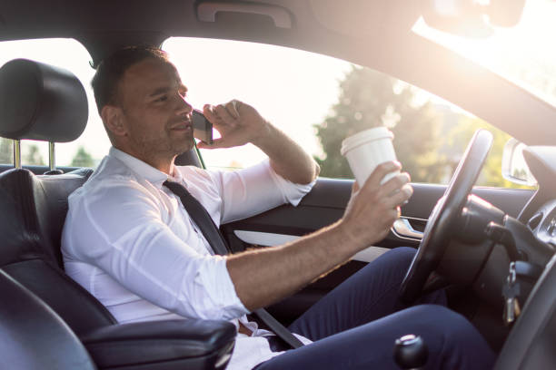 istock Businessman uses a cell phone in a car 1001754418