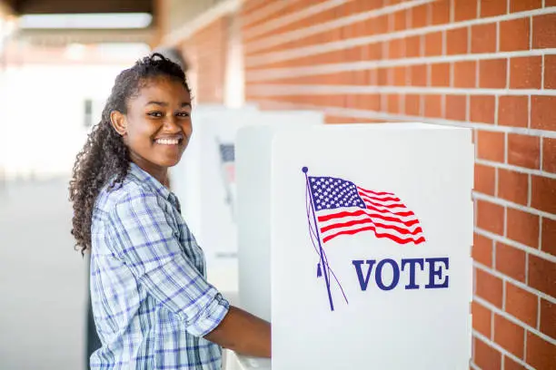 A young black girl voting on election day