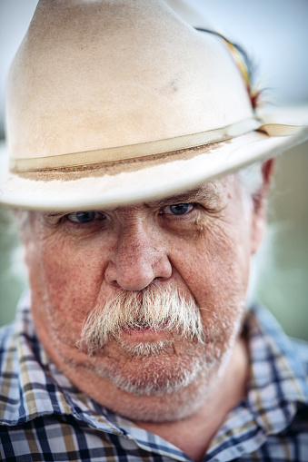 Portrait of Senior cowboy with big ray moustache outdoors.  Outside Salt Lake City, Utah.