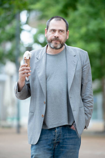 homme adulte mangeant une glace - ice cream parlor ice cream dessert italian culture photos et images de collection