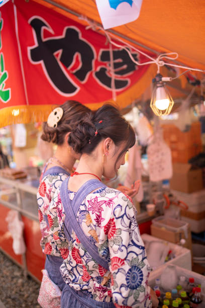 Young matsuri women buying foods at Japanese Yatai food stall Young matsuri women buying foods at Japanese Yatai food stall narita japan stock pictures, royalty-free photos & images