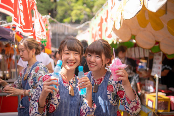 Young women in matsuri cosutume holding kakigori and soda stock photo