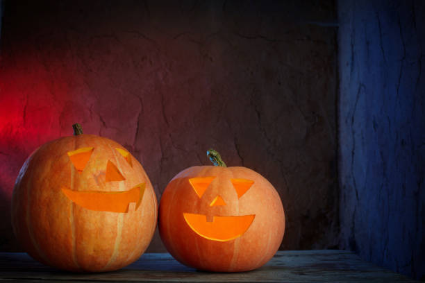 istock Halloween pumpkins on wooden table on dark background 1001814634