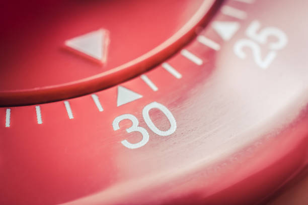 30 minutes - macro of a flat red kitchen egg timer - minute hand fotos imagens e fotografias de stock