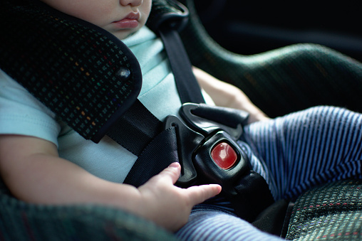 Bebé en la parte posterior hacia el asiento de coche tiene el cinturón de seguridad en photo