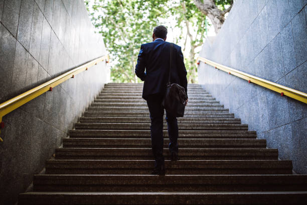 Pedestrian Businessman Walking Out Of Metro Pedestrian Businessman Walking Out Of Metro Up Stairs On Sunny Morning steps and staircases stock pictures, royalty-free photos & images