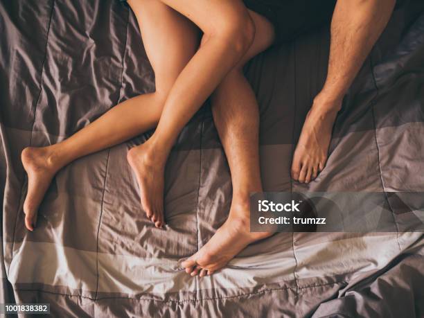 Close Up Of The Legs Of A Couple On The Bed Stock Photo - Download Image Now - Couple - Relationship, Sex and Reproduction, Bed - Furniture