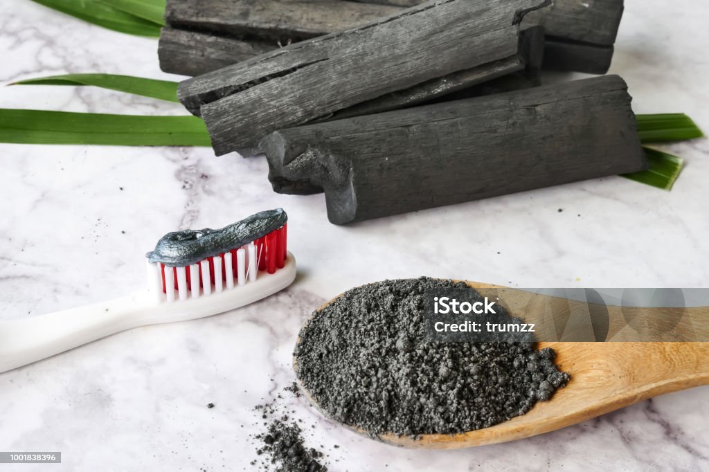 Toothpaste by activated charcoal powder on marble table Coal Stock Photo