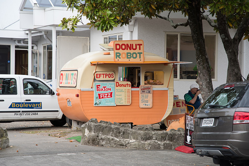 Napier, North Island, New Zealand-December 15,2016: Retro-styled Donut Robot trailer coffee shop with tourist in downtown Napier, New Zealand