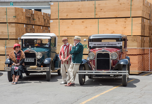 Napier, North Island, New Zealand-December 15,2016: Senior adults dressed in vintage style clothing with antique cars on dock in Napier, New Zealand