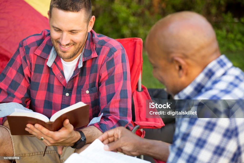 Men having a bible study. Men having a bible study on a camping trip. Group Of People Stock Photo