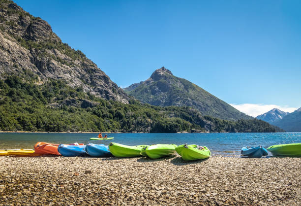 Colorful Kayaks in a lake surrounded by mountains at Bahia Lopez in Circuito Chico  - Bariloche, Patagonia, Argentina Colorful Kayaks in a lake surrounded by mountains at Bahia Lopez in Circuito Chico  - Bariloche, Patagonia, Argentina nahuel huapi national park stock pictures, royalty-free photos & images