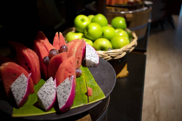 frutta tropicale fresca su foglie di banana e cesto di legno per una sana colazione, pranzo e cena - watermelon market portion basket foto e immagini stock