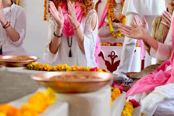 Yoga Students clap and sing at a Kirtan in an Ashram in Rishikesh, India.