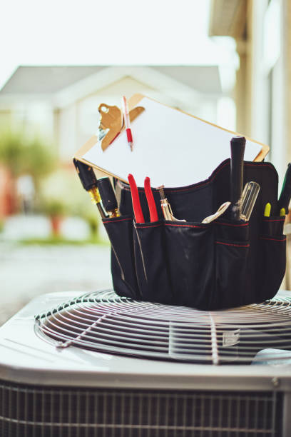 istock Air conditioner with maintenance tools and clipboard in residential back yard 1001912570