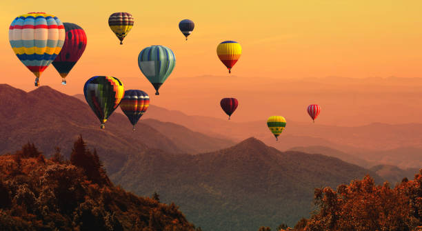 balon na gorące powietrze nad wysoką górą o zachodzie słońca - hot air balloon zdjęcia i obrazy z banku zdjęć