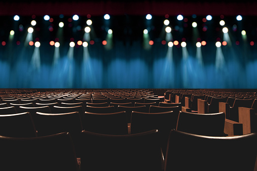 asiento vacío vintage en auditorio o teatro, con luces en el escenario. photo