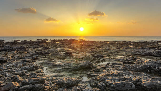 istock Rocky beach uncovered in low tide during evening sunset light with some clouds over horizon. Koh Lanta, Thailand 1001943848