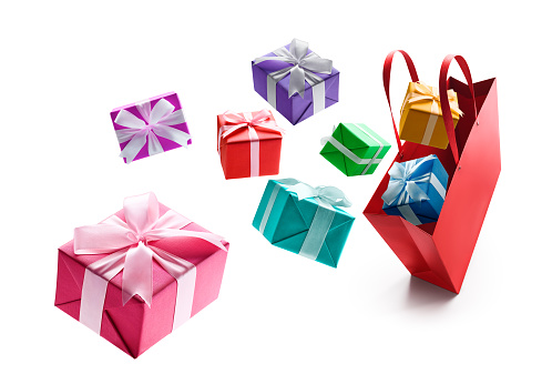 Gift boxes pop out from red shopping bag isolated on white background