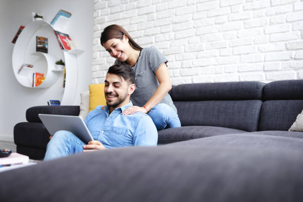 istock Girl Massaging Boyfriend On Sofa At Home 1001955444