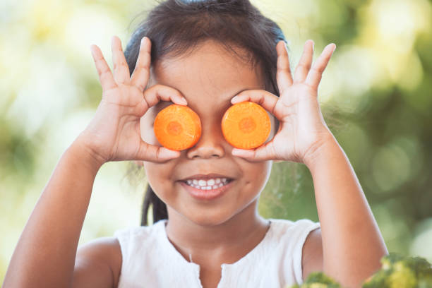 muchacha del niño asiático lindo divertirse aprender sobre verduras - carrot vegetable food freshness fotografías e imágenes de stock