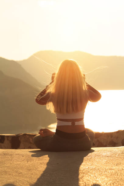 istock Blond young woman practicing yoga at sunset in Santorini Greece 1001969376