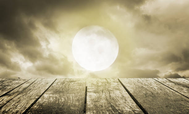 istock Halloween background. Spooky sky with full moon and wooden table 1001974978