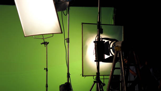 istock Big studio lighting kit 5000 watt with soft box on tripod and professional green screen background chroma key post production technique 1001986854