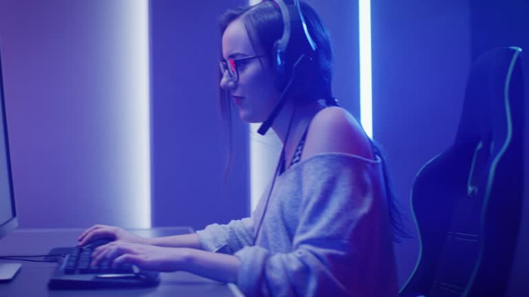 Man gamer teaching his girlfriend playing space shooter video game on RGB  powerful personal computer. Pro cyber woman with headset performing video  games streaming from home during online tournament Stock Photo 