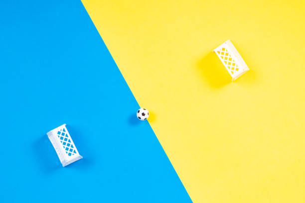 Toy soccer ball and small gates on colorful background