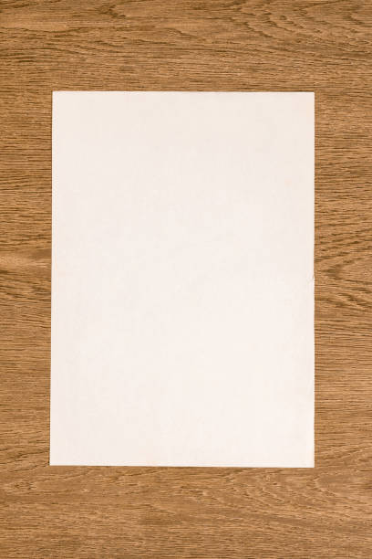 istock view from above of blank white paper on wooden table 1002014080