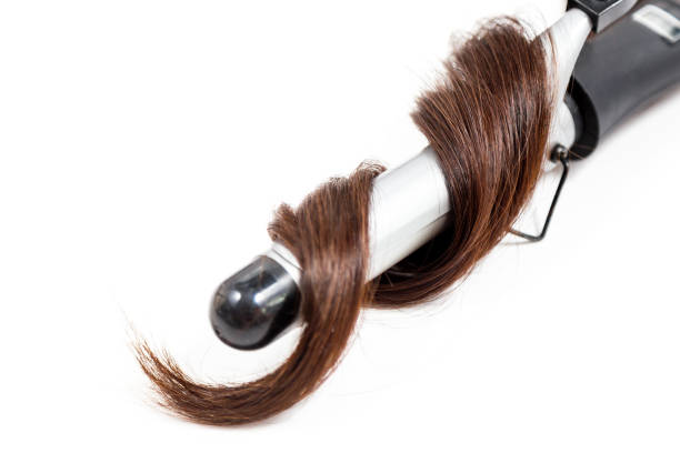 istock Curly dark hair with a curling iron isolated on white background 1002014782