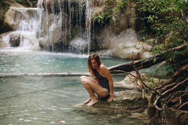 istock White woman enjoying the waterfall 1002016280
