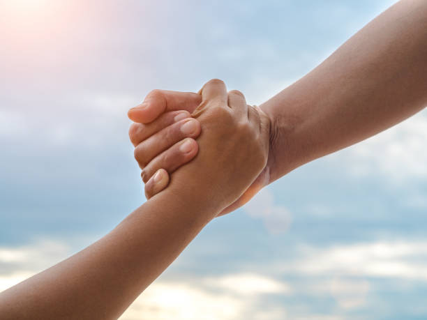 istock Closeup helping hands on the sky background. Rescue & Help Cencept 1002017172