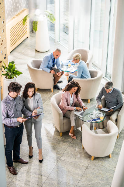 istock Above view of multi-tasking business colleagues working in a hallway. 1002017304