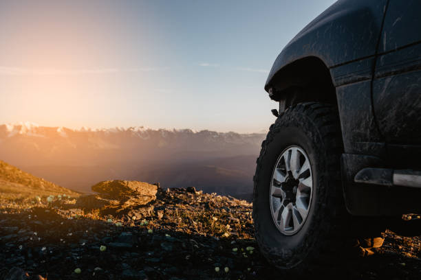 istock Big car wheel is standing on the rocks on mountain backdrop 1002017350