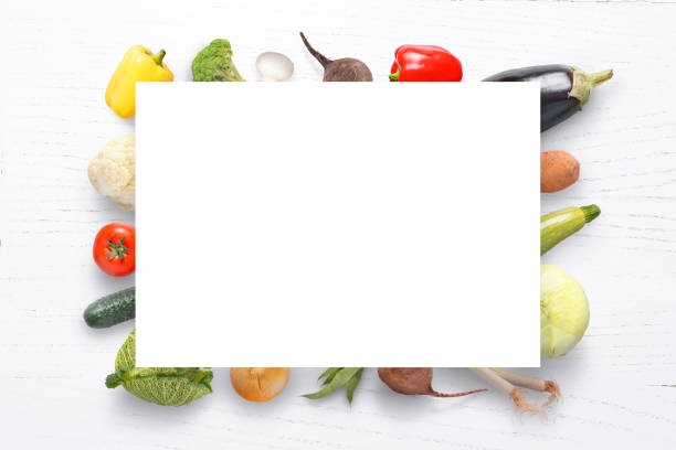 istock Paper and vegetables on white wooden table. Copyspace. Top view. 1002017478