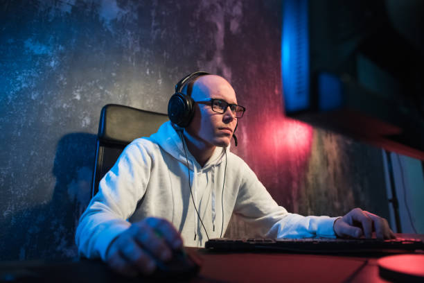 istock male hooded gamer playing online game on pc computer 1002018546