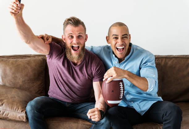 istock Man sitting together on a couch watching sport 1002027210