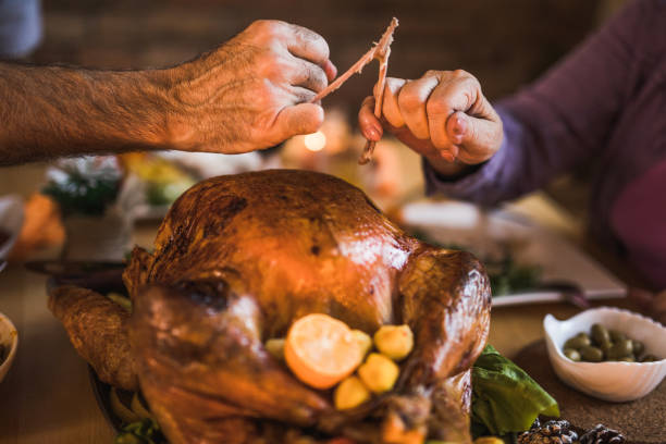 istock Close up of unrecognizable couple pulling wishbone on Thanksgiving dinner. 1002027282