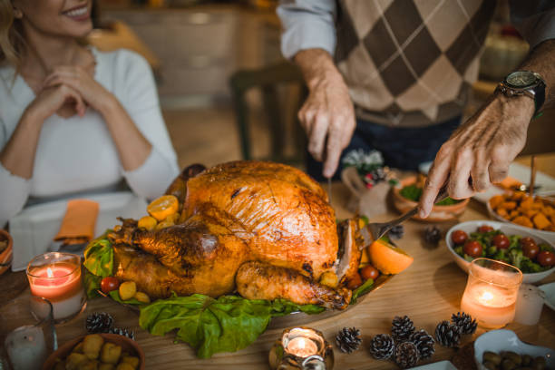 nierozpoznawalna osoba rzeźbi pieczonego indyka podczas kolacji dziękczynnej przy stole. - roast turkey turkey cutting roasted zdjęcia i obrazy z banku zdjęć