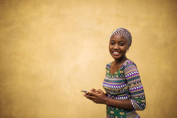 piękny portret młodej afrykańskiej dziewczyny na jej telefonie komórkowym dziewczyna moc - cool youth culture business person women zdjęcia i obrazy z banku zdjęć